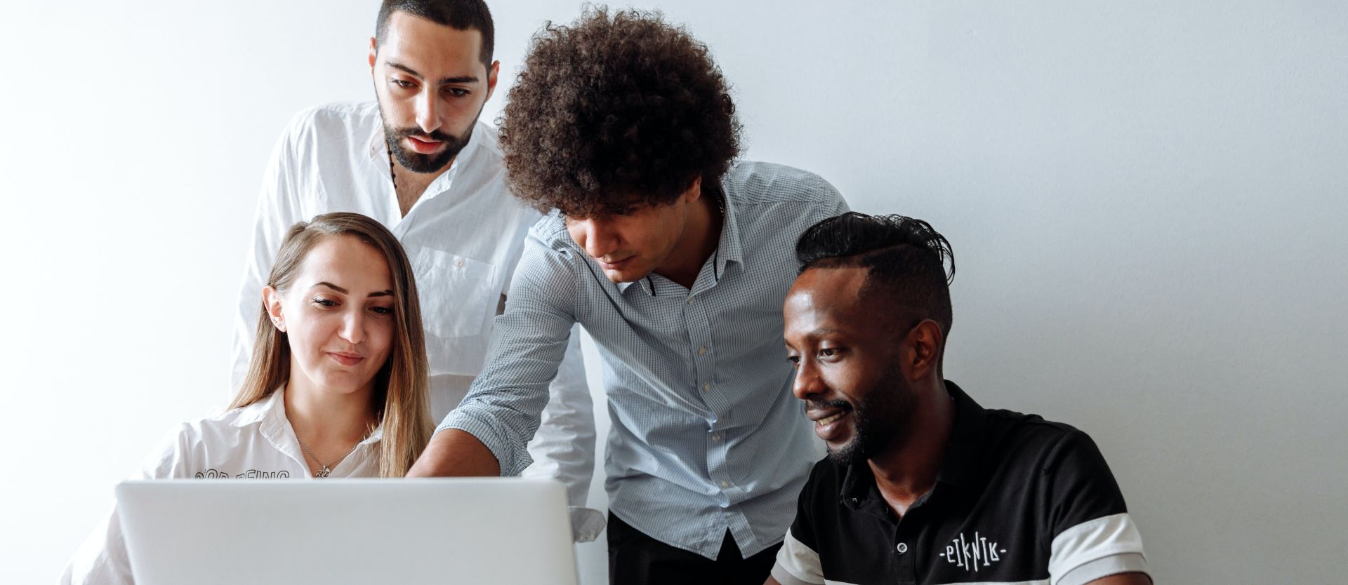 A Group of People Having a Discussion while Looking at Laptop